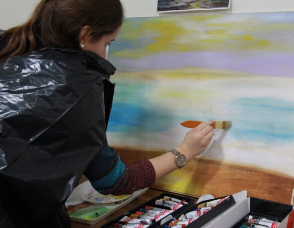 Young woman painting on a canvas.