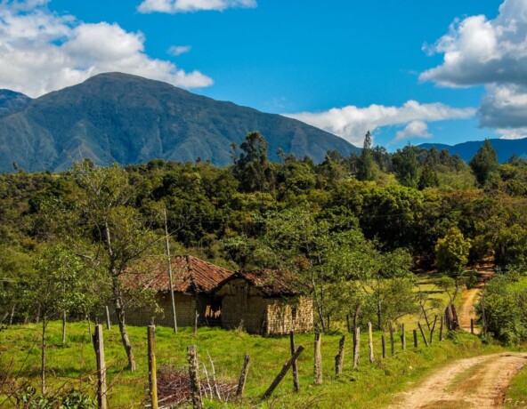 Rural countryside with small brick building in foreground.