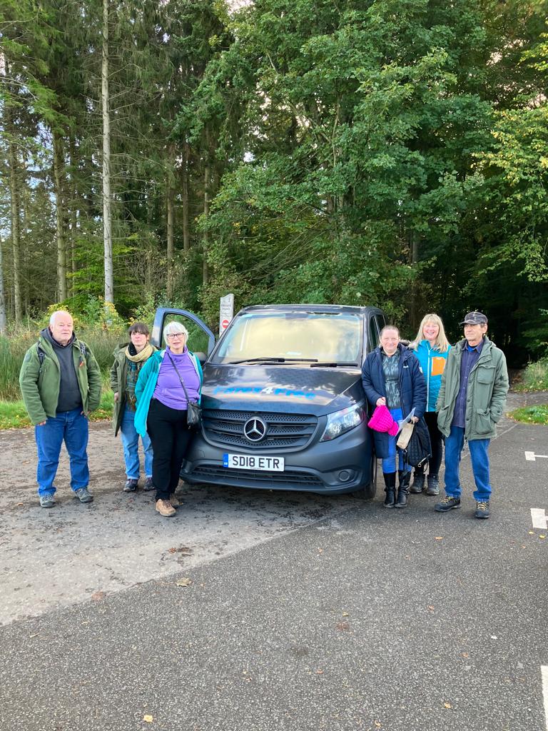 Individuals standing either side of a vehicle