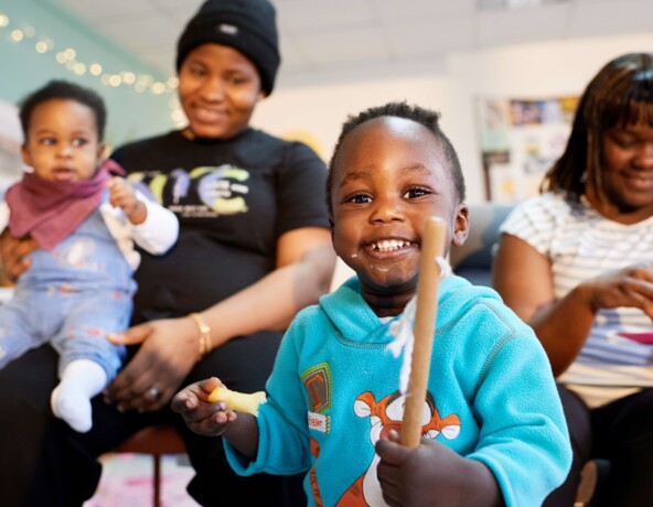 Smiling young boy holding a stick